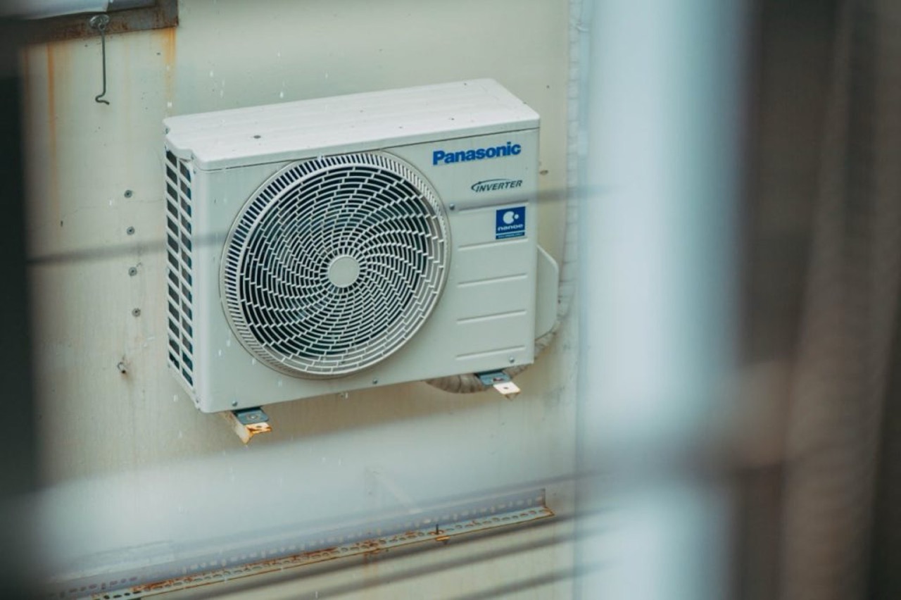 Contractor installing HVAC condenser on commercial site